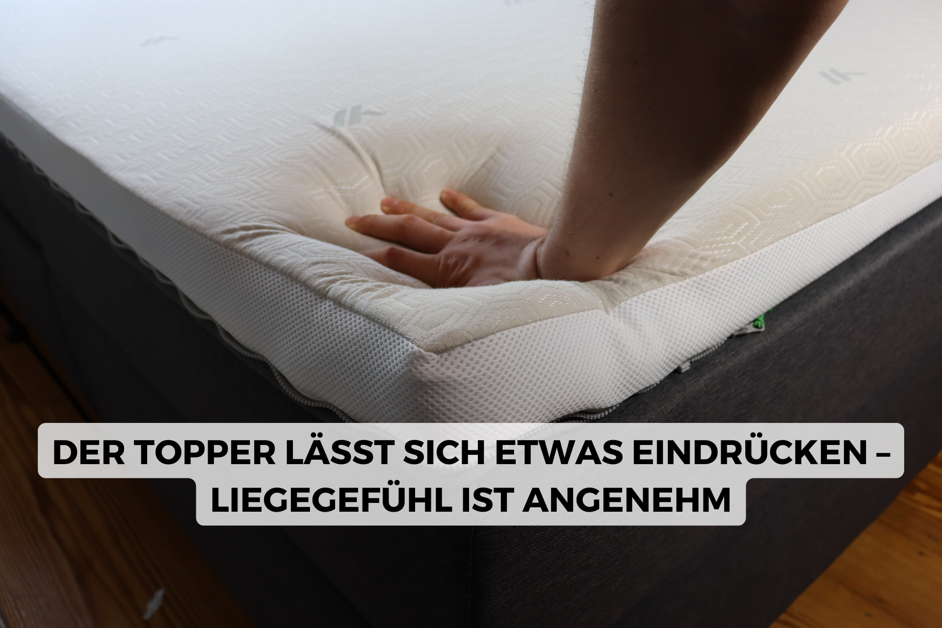 Eine Person drückt den Topper des YAK-Bettes herunter.